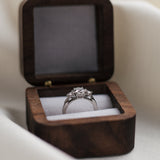 Trilogy diamond ring in a wooden box on a light background