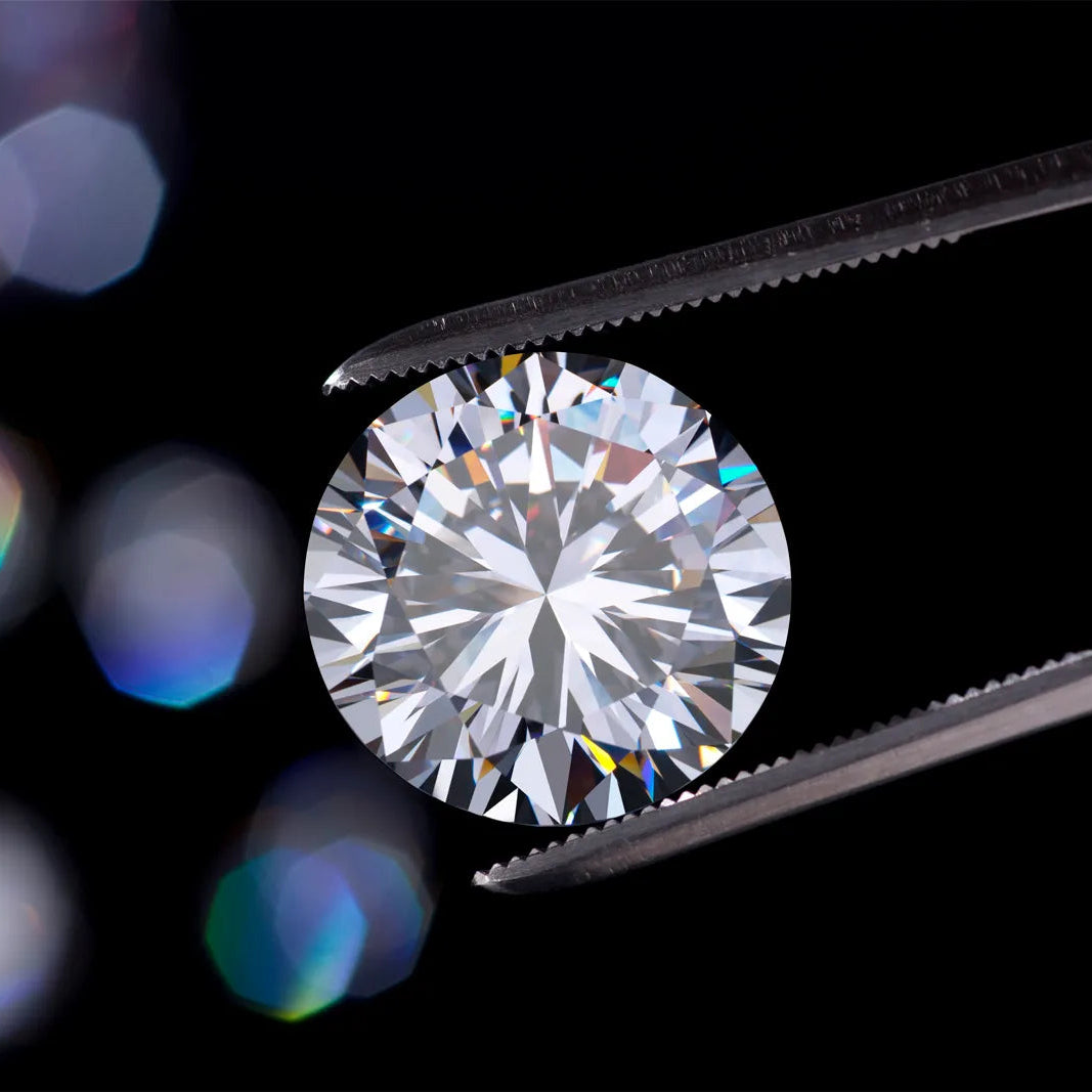 Diamond held by tweezers against a black background with colorful bokeh lights.
