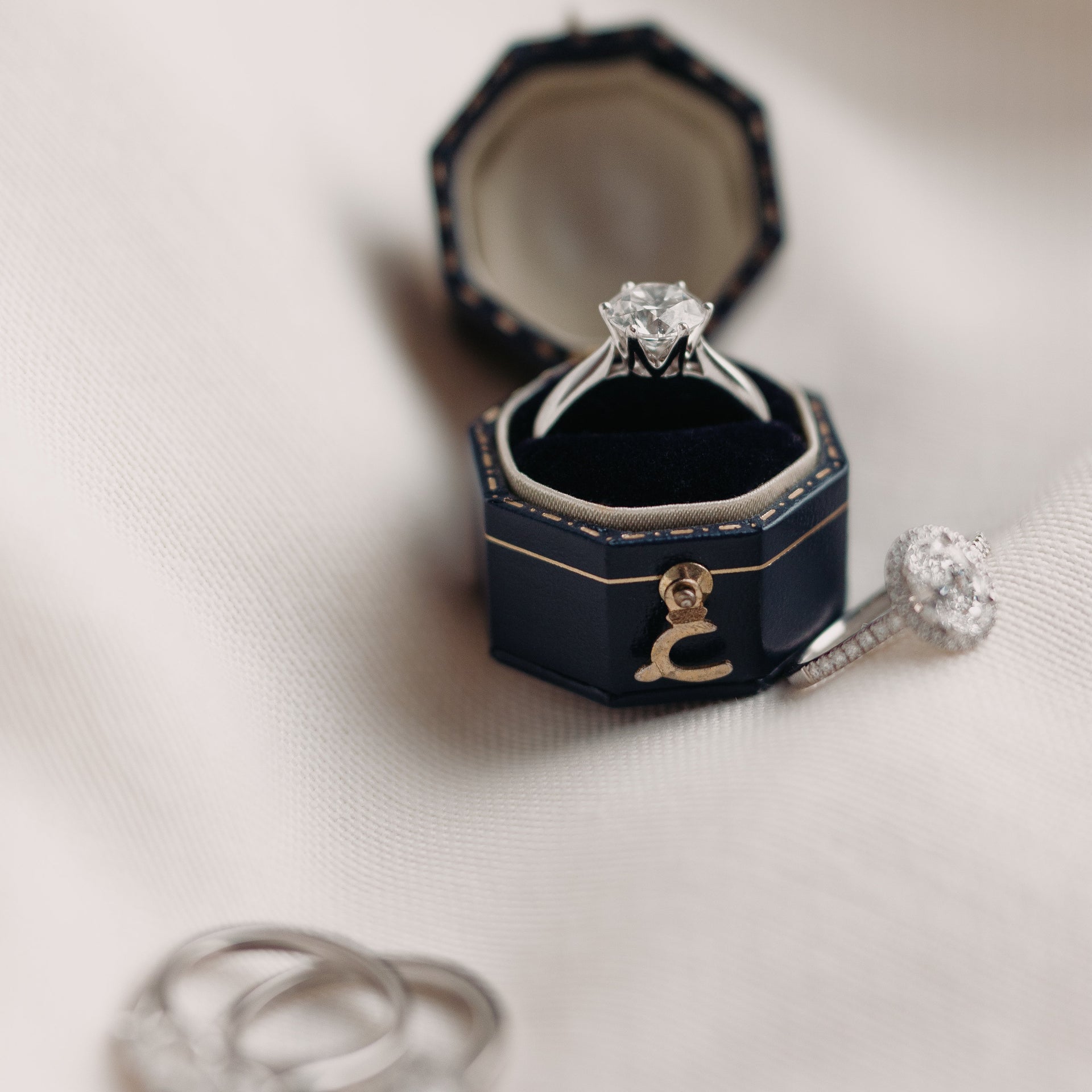 Diamond ring in a hexagonal blue box on a light background