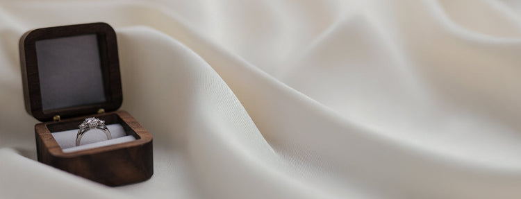 Diamond Platinum Ring in a wooden box on a white fabric background